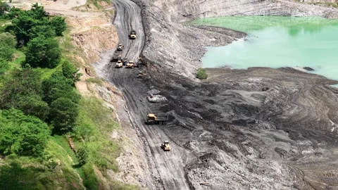 An aerial view of a former coal mine pit filled with blue water shows haul .. Stock Footage 342477572