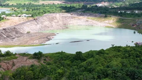 An aerial view of a former coal mine pit filled with blue water shows haul .. Stock Footage 342477709