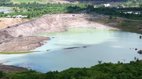 An aerial view of a former coal mine pit filled with blue water shows haul .. Stock Footage 342477751
