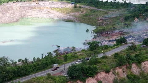 An aerial view of a former coal mine pit filled with blue water shows haul .. Stock Footage 342477793