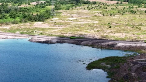 An aerial view of a former coal mine pit filled with blue water, with haul .. Stock Footage 342478897