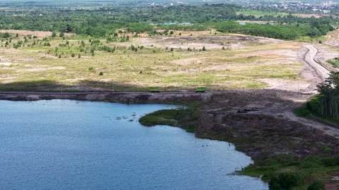 An aerial view of a former coal mine pit filled with blue water, with haul .. Stock Footage 342478939