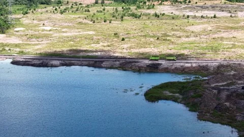 An aerial view of a former coal mine pit filled with blue water, with haul .. Stock Footage 342478974