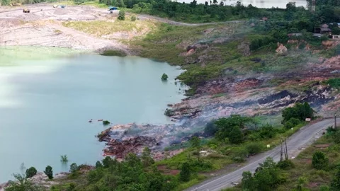 An aerial view of a former coal mine pit filled with blue water shows haul .. Stock Footage 343246152