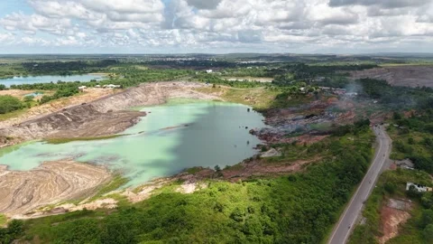 An aerial view of a former coal mine pit filled with blue water shows haul .. Stock Footage 343246476