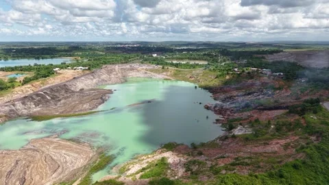 An aerial view of a former coal mine pit filled with blue water shows haul .. Stock Footage 343246575