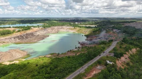 An aerial view of a former coal mine pit filled with blue water shows haul .. Stock Footage 343246596