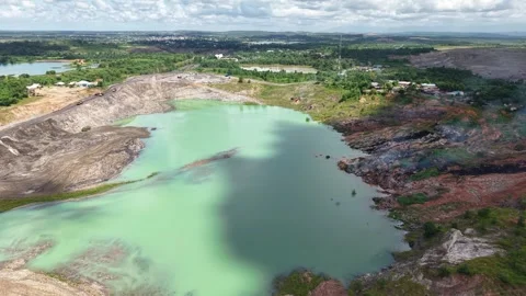 An aerial view of a former coal mine pit filled with blue water shows haul .. Stock Footage 343246717