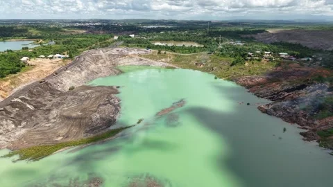 An aerial view of a former coal mine pit filled with blue water shows haul .. Stock Footage 343246806