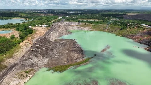 An aerial view of a former coal mine pit filled with blue water shows haul .. Stock Footage 343246819