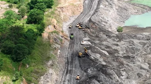 An aerial view of a former coal mine pit filled with blue water shows haul .. Stock Footage 343247210