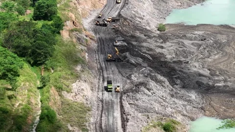 An aerial view of a former coal mine pit filled with blue water shows haul .. Stock Footage 343247356