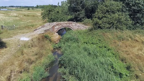 Aerial view, forward up move. Drone hover over old small stone roman bridge Stock Footage 93899575