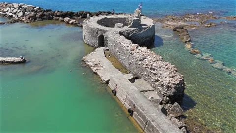 Aerial view forward towards ancient ruins of Venetian castle in the harbor of Stock Footage 331057366