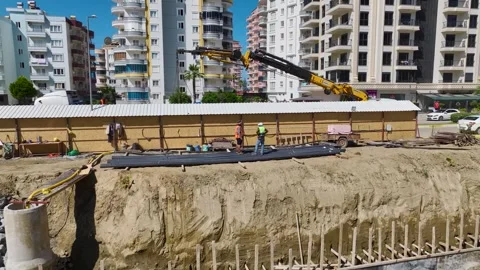 Aerial View: Foundation insulation and metalwork are underway on a large Stock Footage 296094614