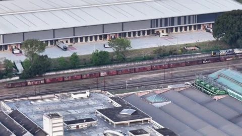 Aerial View of Freight Train and Industrial Rail Yard by Warehouse Stock-Footage 343993474