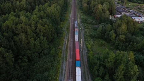 Aerial view of the freight train, carrying rubble and cement, moving through the Stock Footage 113530032