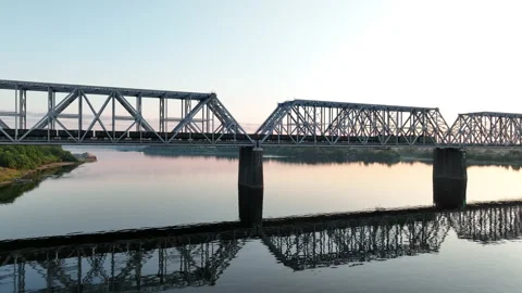 Aerial view. A freight train with many wagons moves over river at railway bridge Stock-Footage 218602165