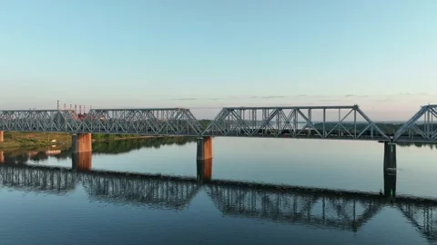 Aerial view. A freight train with many wagons travels over a railway bridge  Stock Footage 234536247