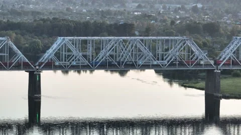 Aerial view. A freight train with many wagons travels over a railway bridge  Video stock 234536426