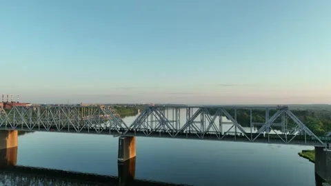 Aerial view. A freight train with many wagons travels over a railway bridge  Stock Footage 234539479