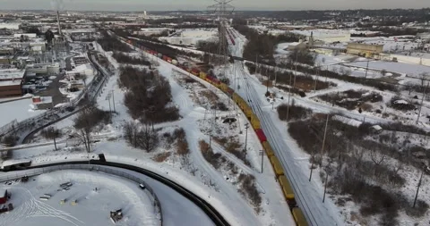 Aerial view of a freight train moving through a snowy landscape, United States. Stock Footage 334299567
