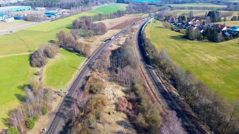 Aerial view of freight train on parallel railway tracks through rural farmland 库存影片 333721846