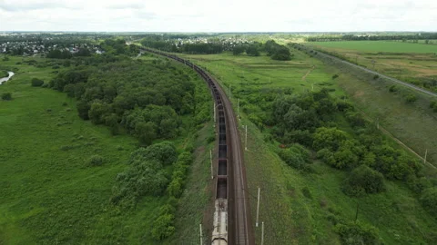 Aerial view of freight train traversing lush green landscape, showcasing scenic Stock Footage 316248989