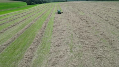 Aerial view from front and overhead of tractor working in a field Stock Footage 276963325