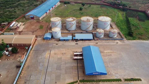 Aerial view of a fuel storage facility with large tanks and blue buildings in a Stock Footage 316948824