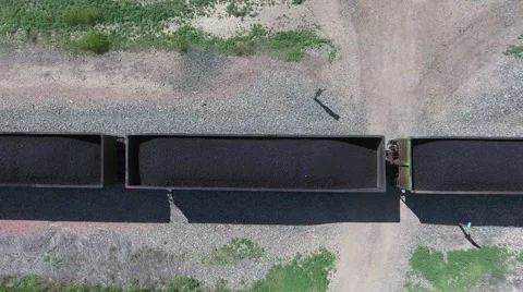 An aerial view of a full coal train moving through the countryside. Stock Footage 64978866