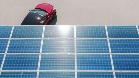 Aerial view fully charged red electric car driving away from EV charging station Stockbeeldmateriaal 204880284