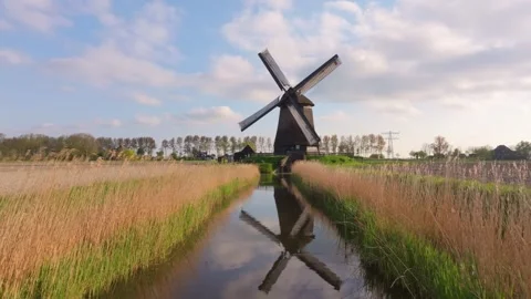 Aerial view of functional windmill standing tall in rural Dutch landscape 動画素材 313364393