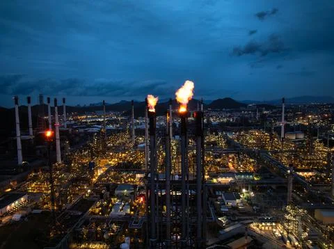 Aerial view of gas flare stack burning fire in oil refinery plant at night .. 스톡 사진