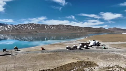 Aerial View of Geodesic Dome Camp by Reflective Lake and Snowy Mountains Tibet Stock Footage 339313408