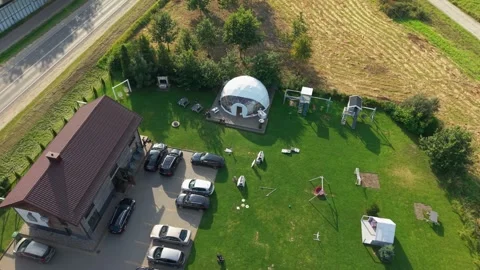 Aerial view of a geodesic dome setup for an outdoor event with playgrounds Vídeo Stock 319521056