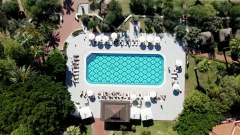 Aerial View of Geometric Patterned Pool with Sun Loungers and Umbrellas Stock Footage 296515279