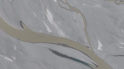 Aerial view of a glacier-fed river winding through the rugged mountains of 스톡 동영상 314455080