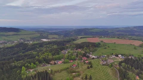 Aerial view gliding over rolling countryside village with patchwork green Stock Footage 347912959
