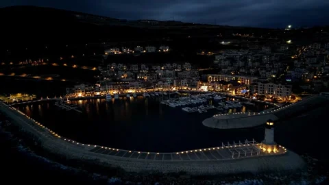 Aerial view of the glowing lighthouse and the seaside town of Lustica in Stock Footage 297212329