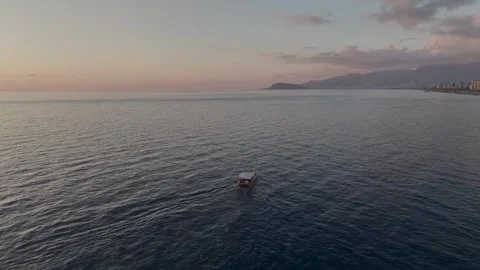 Aerial View: A glowing sunset illuminates the fishing boat on calm waters, with Stock-Footage 296079528