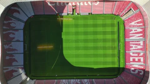 Aerial view going down over the Benfica stadium with two lawnmowers taking care Stock Footage 318904180