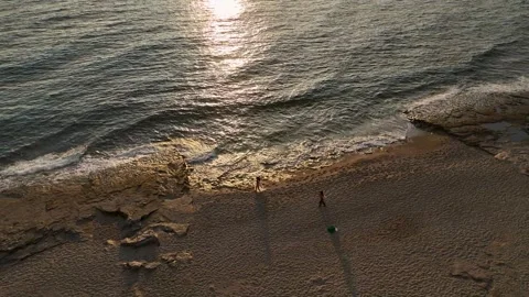 Aerial View: The golden rays of the setting sun pierce through dramatic clouds Stock Footage 296031521