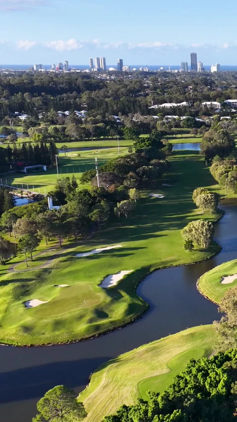 Aerial View of Golf Course Fairway with City Skyline Background 動画素材 339540609