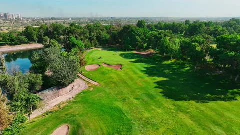 Aerial view of golf course with golfers. Drone flying over golf club in summer Stock Footage 247946399