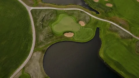 Aerial view of golf course with green field in the valley. Landscape with a lake Stock Footage 124379723