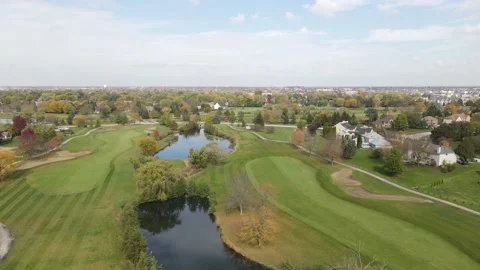 Aerial view of a golf course with ponds. Man fast driving cut grass lawn mower Stock Footage 142659672
