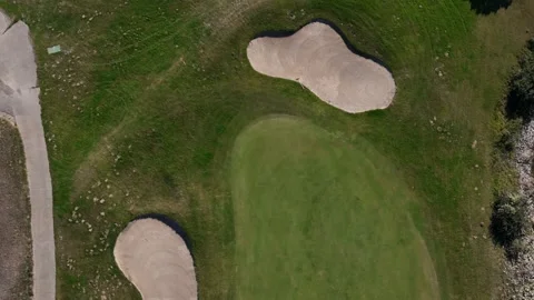 Aerial view of a golf course with sand traps and a golf cart on the path Stock Footage 286222256