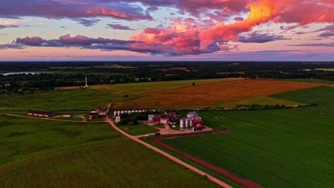 Aerial view of a grain elevator and farm fields during a vibrant colorful Stock Footage 343978783