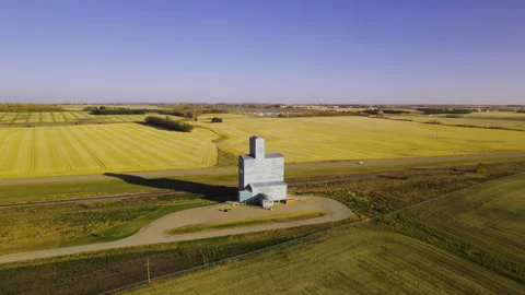 Aerial view grain elevator standing out between farm land. Alberta prairies Stock Footage 248134804